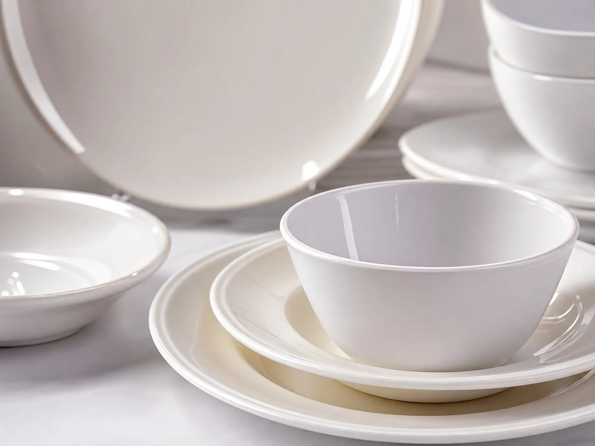 White custom melamine dinnerware set featuring stacked bowls and plates for OEM manufacturing